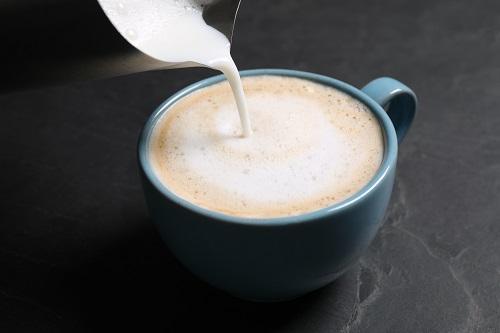 コーヒー カップにミルクを注ぐ