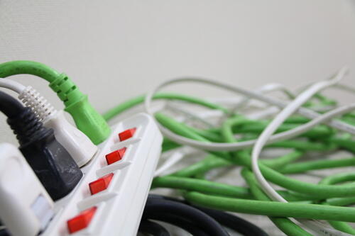 テーブルタップとごちゃごちゃに絡まっているコードの写真