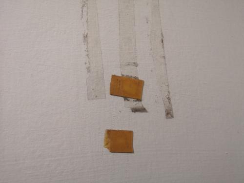 壁に貼り付いた両面テープの写真