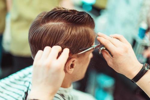 髪をカットしてもらっている男性の写真