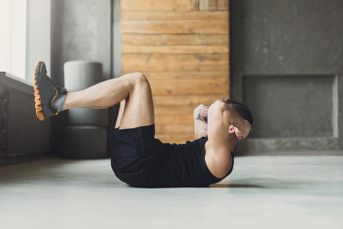 足を上げて腹筋をする男性の写真