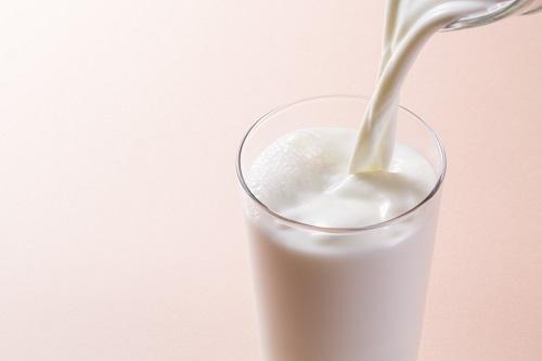 グラスにミルクを注いでいるところの写真